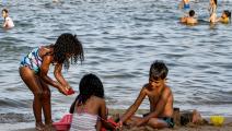 أطفال يستمتعون باللعب على الشاطئ (فتحي بلعيد/ فرانس برس)