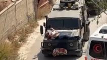 قوات الاحتلال تربط شاباً فلسطينياً مصاباً بمقدمة عربة عسكرية (مواقع التواصل)
