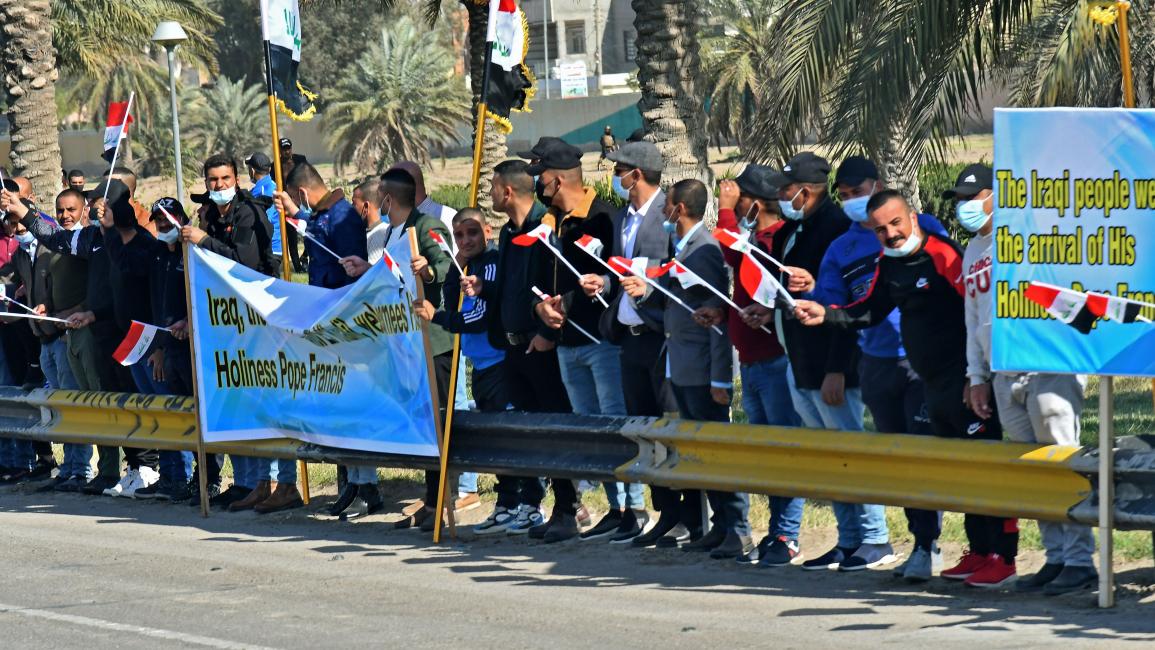 عراقيون يرحبون بالبابا خلال وصوله إلى مطار بغداد (فينسينزو بينتو/فرانس برس)