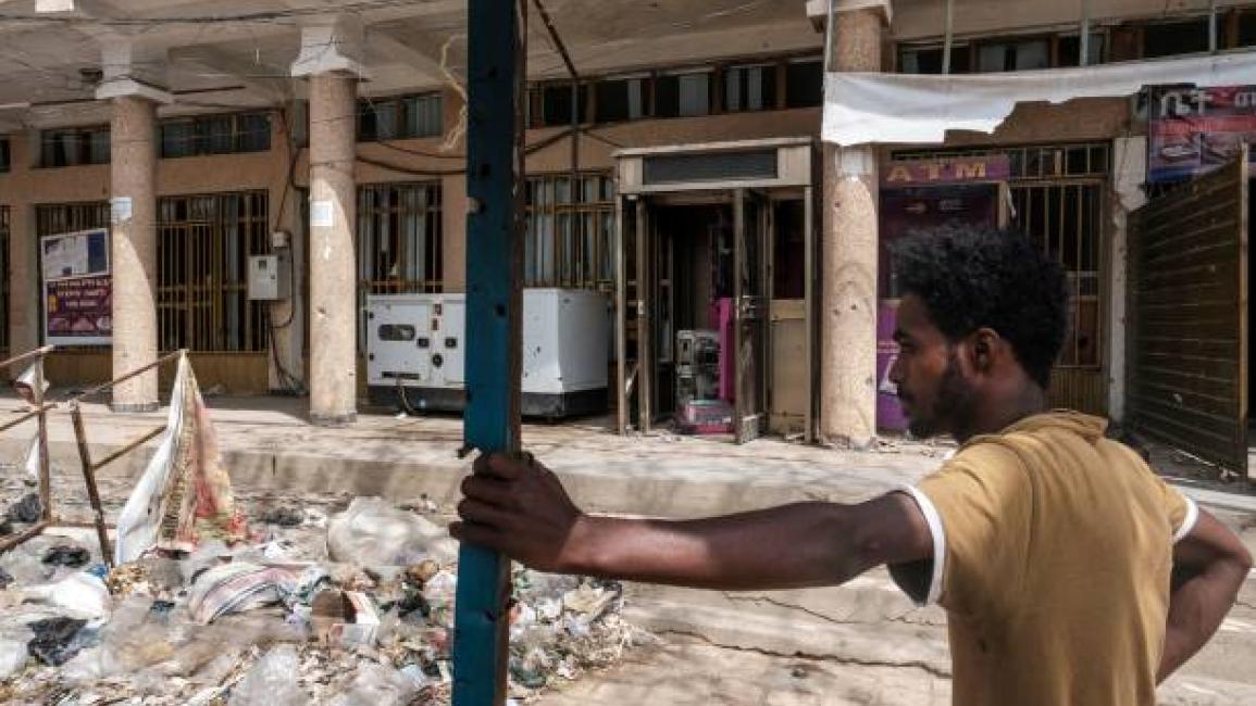 	A man stands in front of a bank which was allegedly looted by Eritrean forces, in Wukro, north of Mekele, on March 1, 2021. - Every phase of the four-month-old conflict in Tigray has brought suffering to Wukro, a fast-growing transport hub once best-known for its religious and archaeological sites. Ahead of federal forces' arrival in late November 2020, heavy shelling levelled homes and businesses and sent plumes of dust and smoke rising above near-deserted streets. Since then the town has been heavily pat