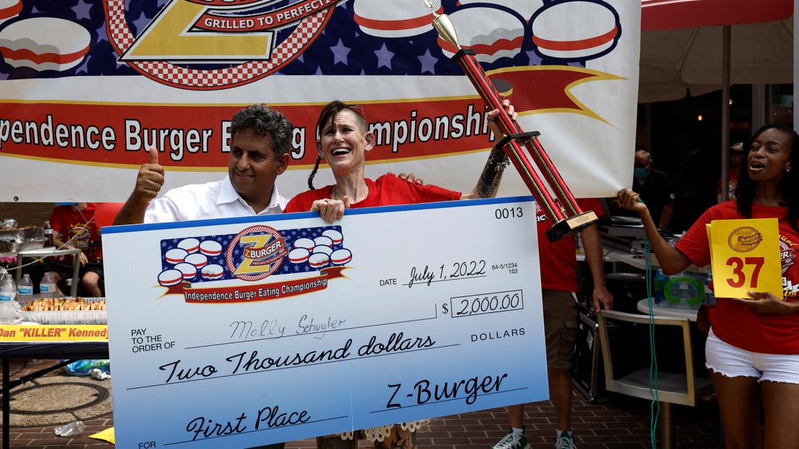الفائزة مولي شويلر تتسلم الجائزة بقيمة 2000 دولار أميركي من مالك المطعم (آنا مونيميكر/Getty)