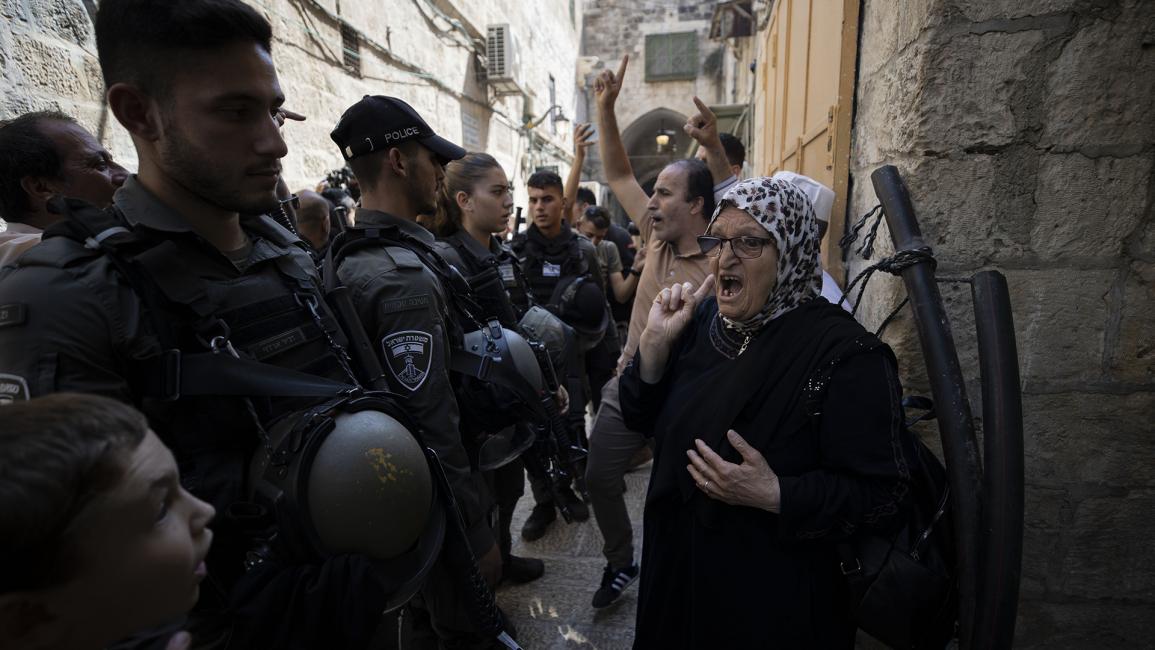 مسنة فلسطينية تتحدى المستوطنين وقوات الاحتلال (مصطفى الخروف/الأناضول)
