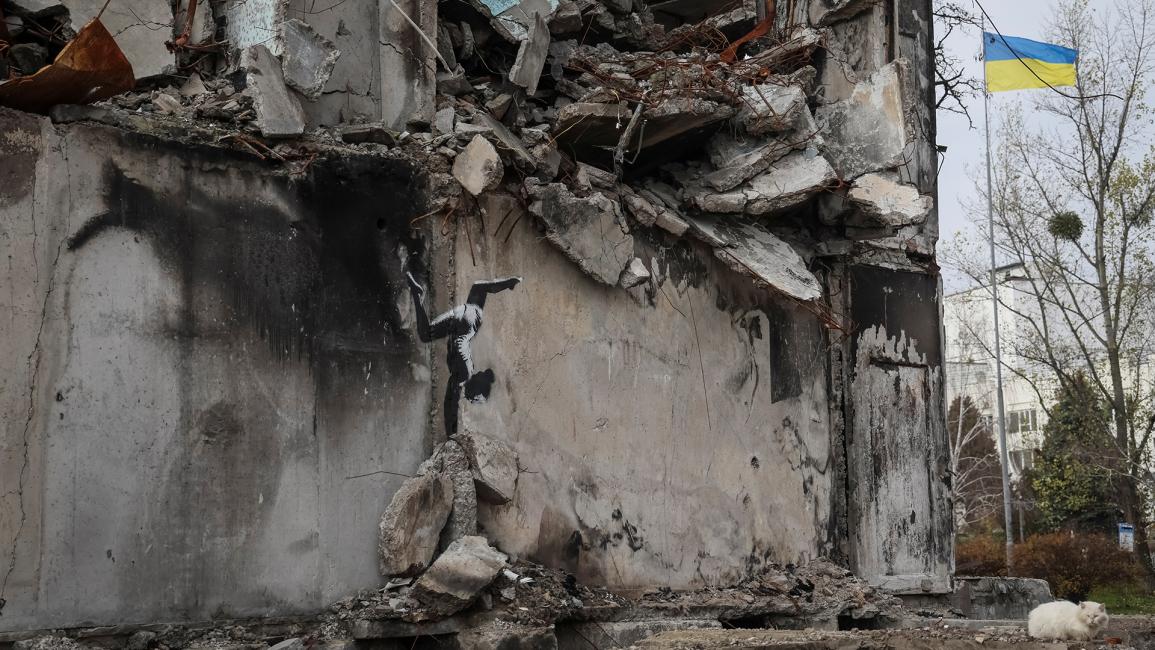 يُظهر العمل الفني لاعبة جمباز تتوازن على كومة من الأنقاض، إلى جانب مبنى دمرته الضربات الروسية (جليب جارانيش/رويترز)