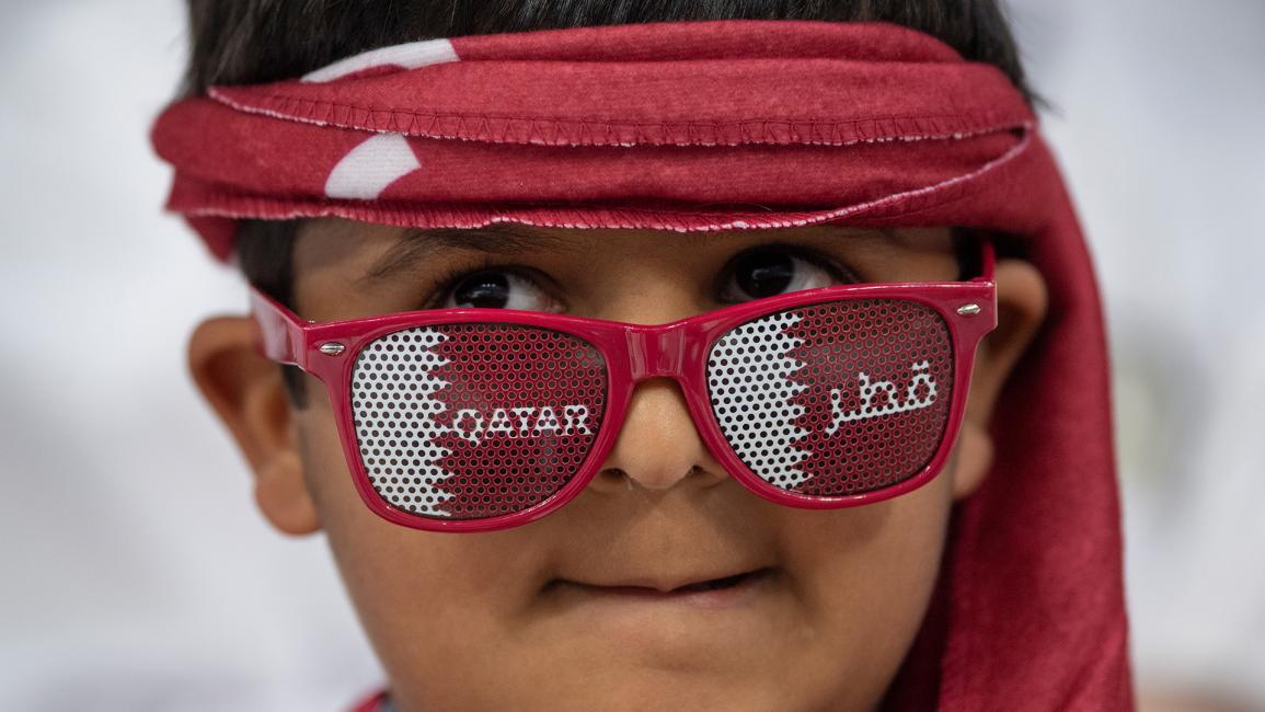 مشجع شاب يرتدي نظارة شمسية قطرية ووشاح رأس (Visionhaus / Getty)