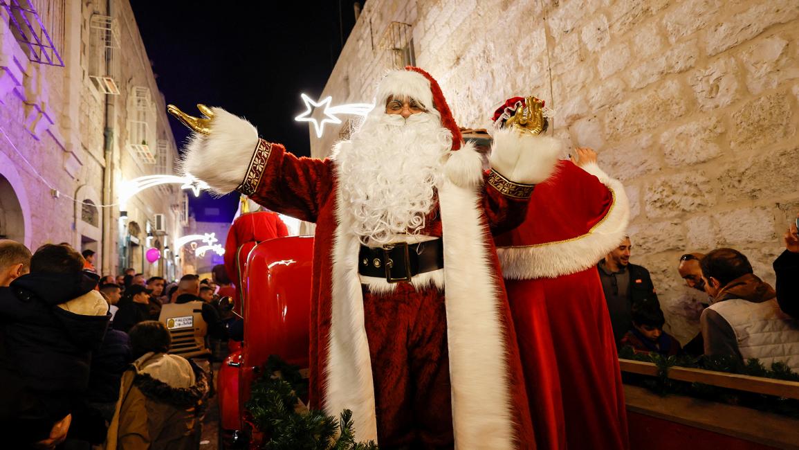 فلسطيني يرتدي زي بابا نويل خلال احتفال في بيت لحم بالضفة الغربية المحتلة (موسى قواسمة/رويترز)