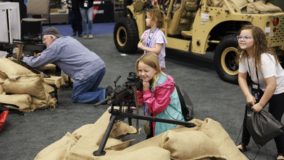طفلة أميركية تجرب سلاحاً في معرض (جيرمي هوغان/Getty)