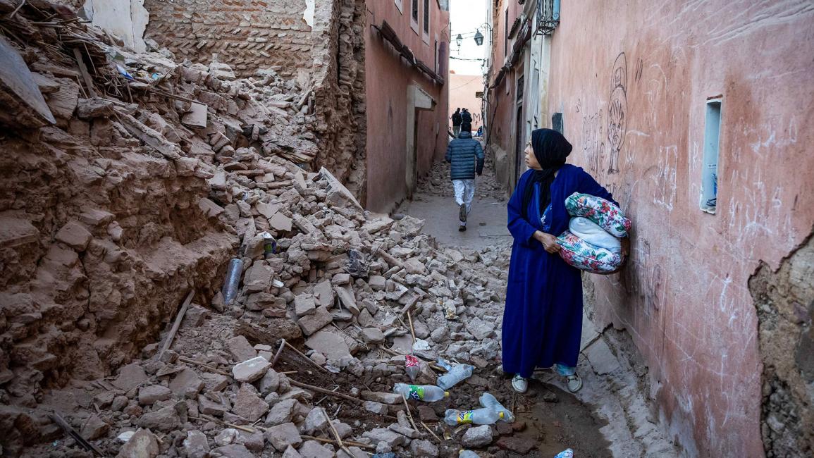 امرأة تنظر إلى أنقاض مبنى في المدينة القديمة (فاضل سينا/ Getty)