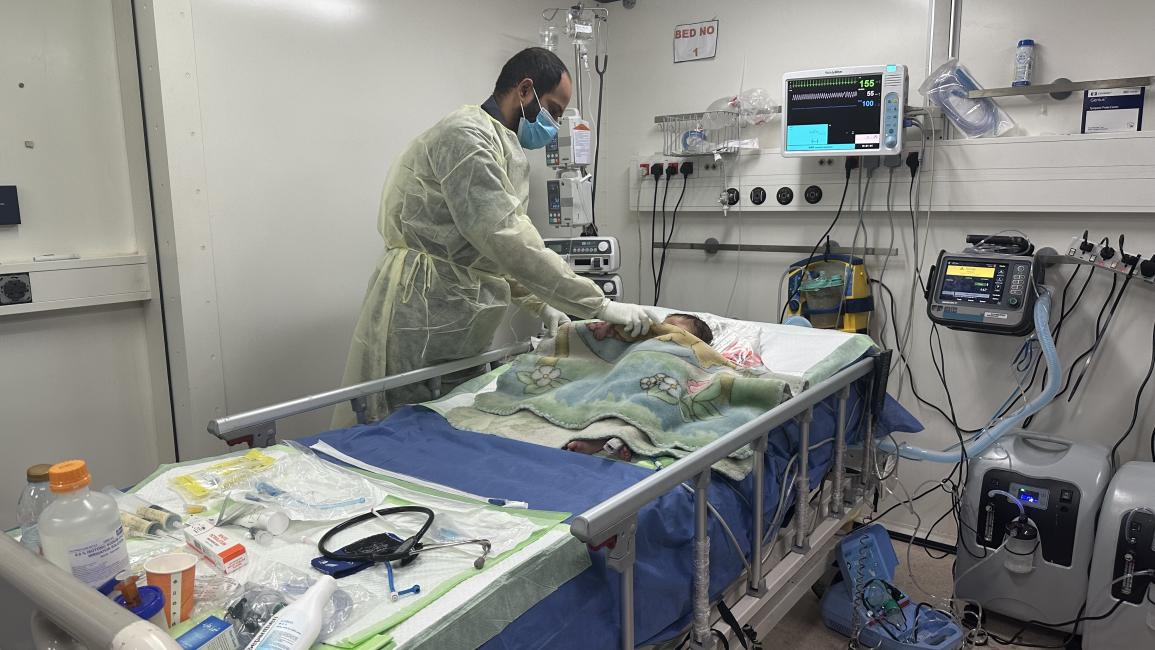 يعاين طفلاً في المستشفى الإماراتي الميداني (علاء أبو محسن/ الأناضول)