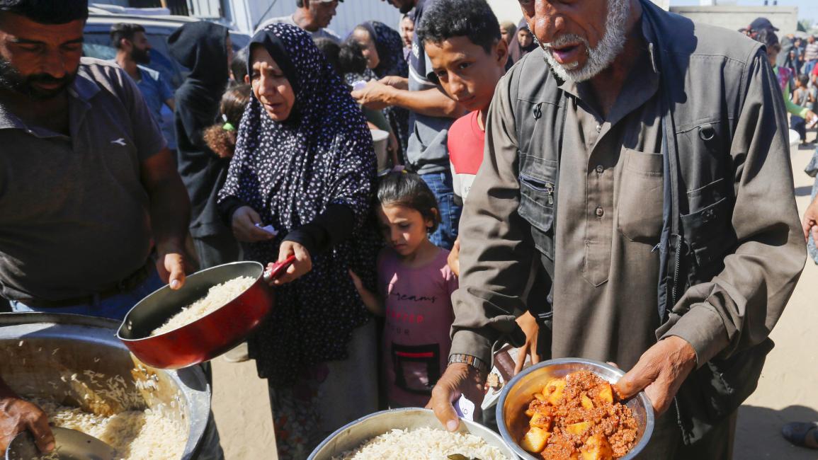 طابور للمساعدات الغذائية في دير البلح (أشرف أبو عمرة/الأناضول)