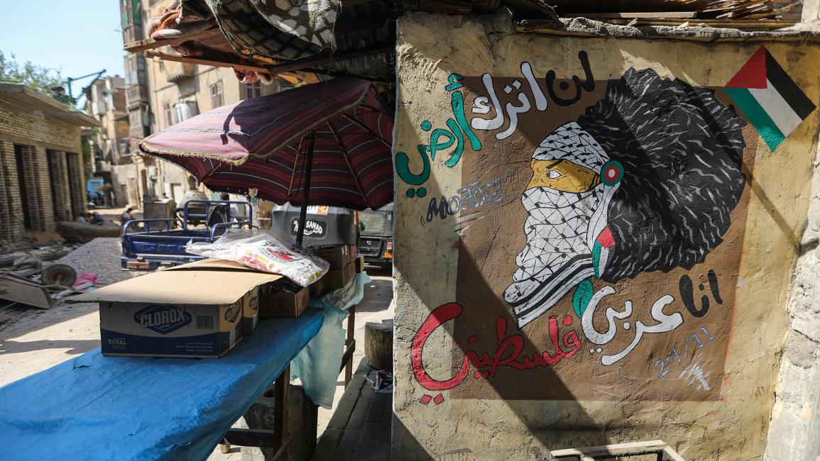 رسم يجمع بين الفلسطينيين والهنود الحمر وكتابة "لن أترك أرضي، أنا عربي فلسطيني" (أحمد حسب الله/ Getty)