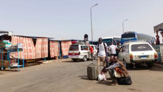 فارون من السودان ينتظرون باصات لنقلهم إلى أسوان بمصر (فرانس برس) 