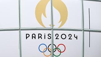 شعار دورة الألعاب الأولمبية باريس 2024، في 13 يوليو 2024، في منطقة لا ديفانس في باريس (أرتور فيداك/ Getty)