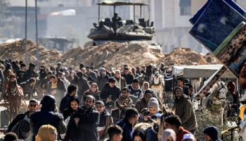 فلسطينيون ينزحون من خانيونس على مقربة من دبابة إسرائيلية، 30 يناير 2024 (Getty)