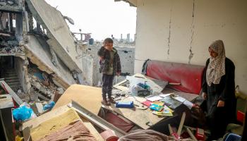 امرأة فلسطينية وطفلُها في بيتهما الذي هدمه القصف الإسرائيلي، خانيونس جنوبيّ غزّة، 25 تشرين الثاني/ نوفمبر (2023)