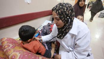طبيبة وطفل في رواق مشفى الأقصى، 6 مارس 2024 (أشرف عمرة/ الأناضول)