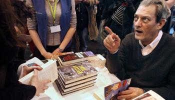 بول أوستر أثناء توقيعه نسخاً من كتبه في "معرض باريس للكتاب"، 2010 (Getty)