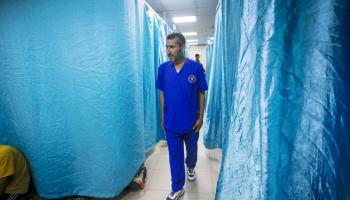 الطبيب الفلسطيني عصام أبو عجوة في مستشفى الأهلي المعمداني في دير البلح (الأناضول)