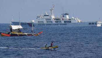 سفينة خفر السواحل الصينية تراقب الصيادين الفلبينيين على متن قواربهم 16 مايو 2024 (Getty)