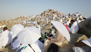 حجاج يحتمون من الحر الشديد بجبل عرفات، 15 يونيو 2024 (الأناضول)