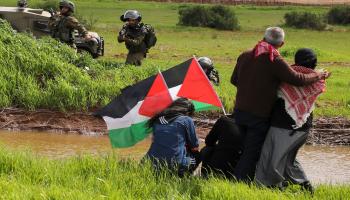 جنود الاحتلال يصوّبون أسلحتهم على متظاهرين فلسطينيين(جعفر إشتية/فرانس برس)