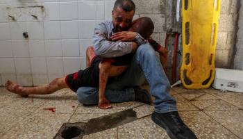 أب يحتضن جثه ابنه بعد استشهاده بغارة إسرائيلية وسط قطاع غزة (رويترز)