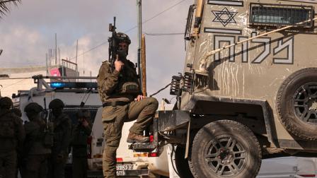جندي إسرائيلي قرب مركبة عسكرية في الضفة الغربية، 1 يناير 2024 (فرانس برس)