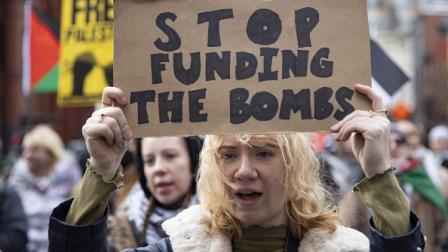 "أوقفوا تمويل الأسلحة" لافتة خلال تظاهرة في واشنطن تضامناً مع غزة 27/2/2024 (مصطفى باسم/الأناضول)