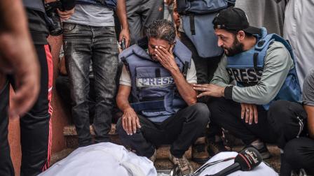 صحافيان يبكيان في جنازة الصحافي محمد أبو حطب في غزة، 3 نوفمبر 2023 (عبد زقوت/ الأناضول)