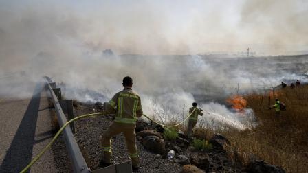 عمال إطفاء إسرائيليون يحاولون إخماد النيران في حقل بهضبة الجولان المحتلة بعد سقوط صواريخ لحزب الله، 2 يونيو 2024 (فرانس برس)