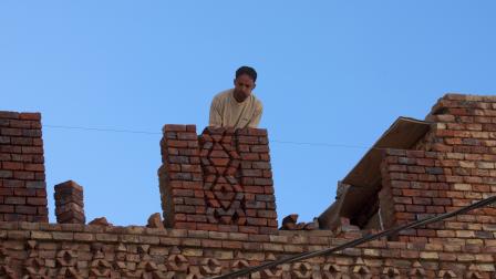 عامل بناء أثناء تشييد أحد المنازل في صنعاء (إريك لافورجو/Getty)