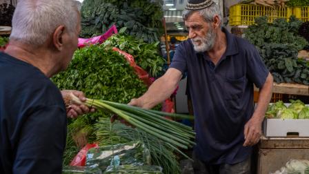 بائع خضروات في سوق الكرمل بتل أبيب، 25 مايو 2023 (Getty)