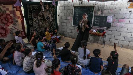 أطفال فلسطينيون يدرسون في خيمة بدير البلح، في 9 يونيو 2024(الأناضول)