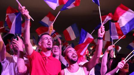 رفع أعلام فرنسا بينما تلقي لوبان خطابا، 30 يونيو. 2024 (فرانس برس)