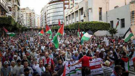 مغاربة يلوحون بالأعلام الفلسطينية خلال مسيرة تضامنية مع غزة 7 يوليو 2024 (Getty)