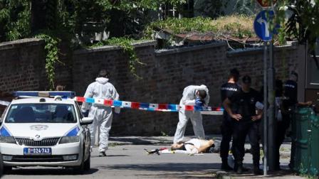 الشرطة الصربية تحيط بجثة المهاجم بمحيط السفارة، بلغراد 29 يونيو2024 (زورانا جيفتيك/رويترز)